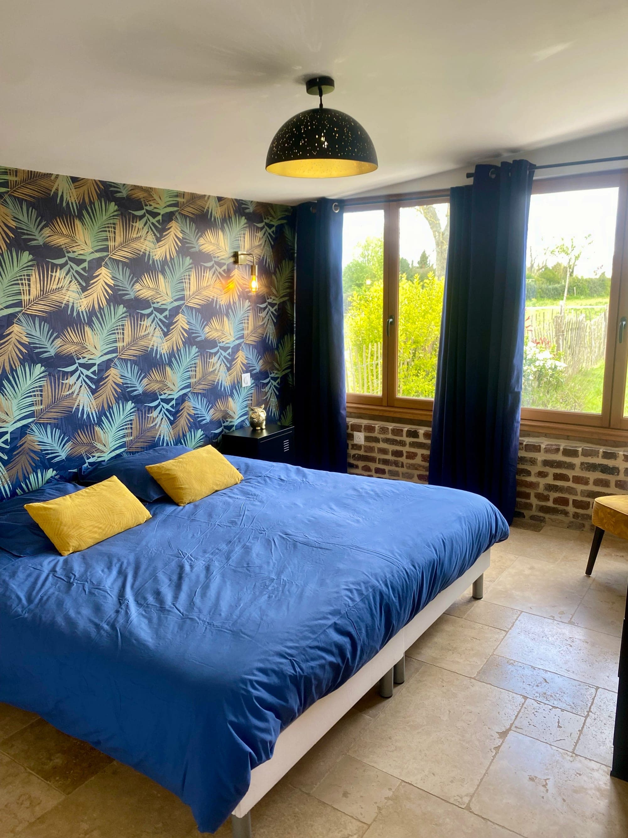 Bedroom 1 at Gîte Cerise with a 200 × 200 cm king-size bed and an exposed brick wall