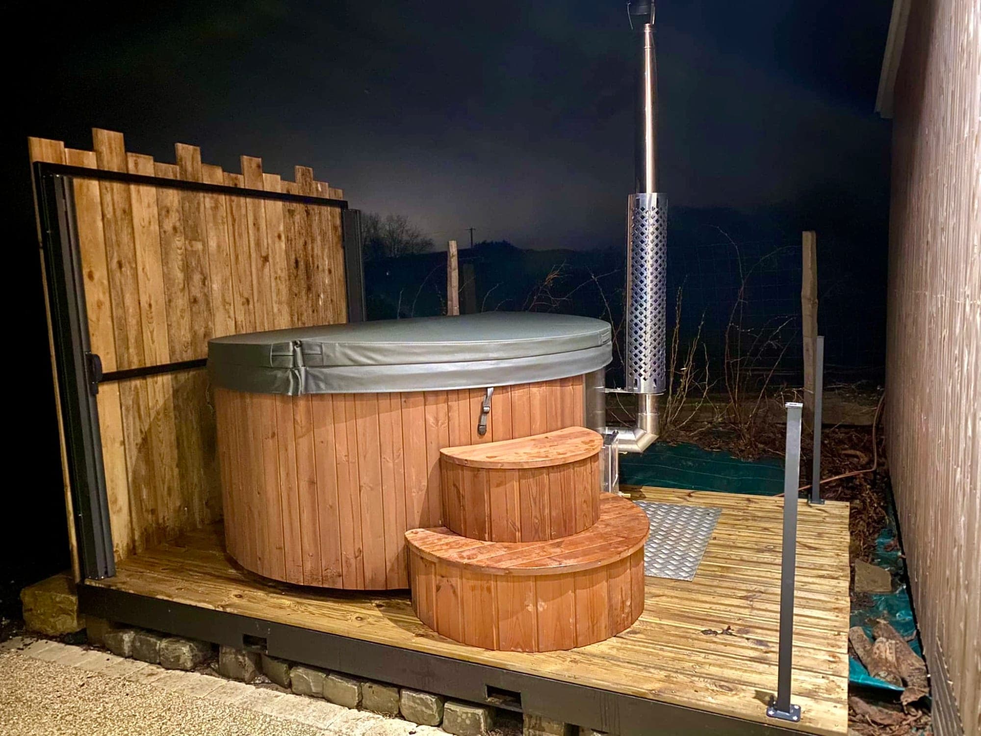 Private nordic bath at Gîte Mirabelle lit up at night, open all year round