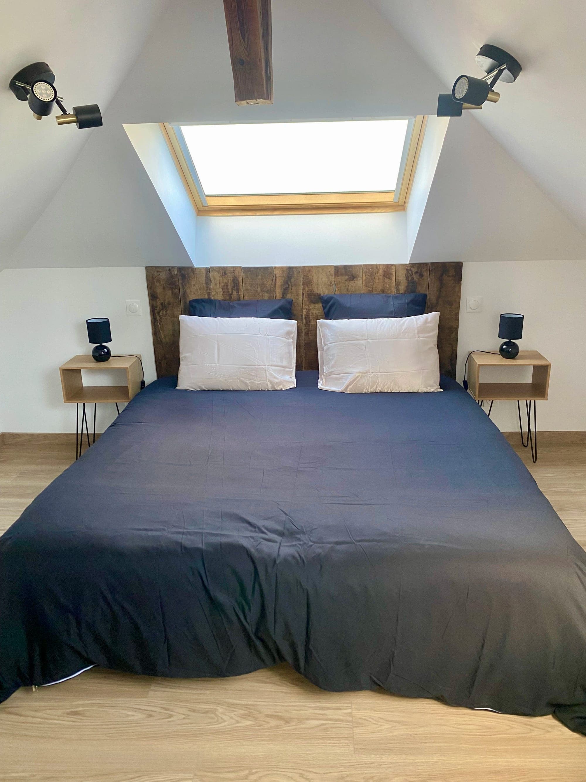 Attic bedroom 1 at Gîte Mirabelle with a king-size bed and a wooden headboard