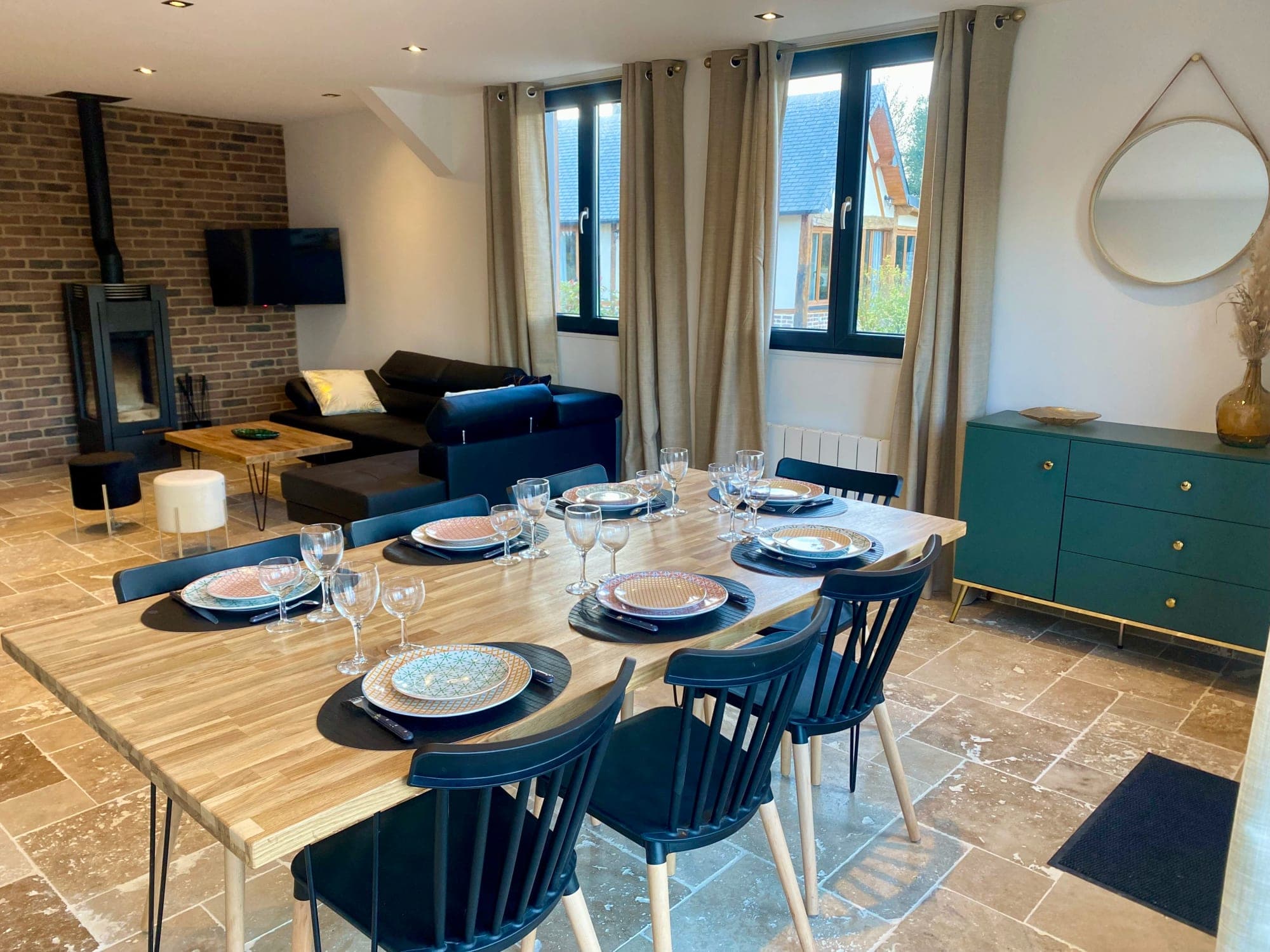 Living space at Gîte Mirabelle: dining area, sitting area and wood-burning stove