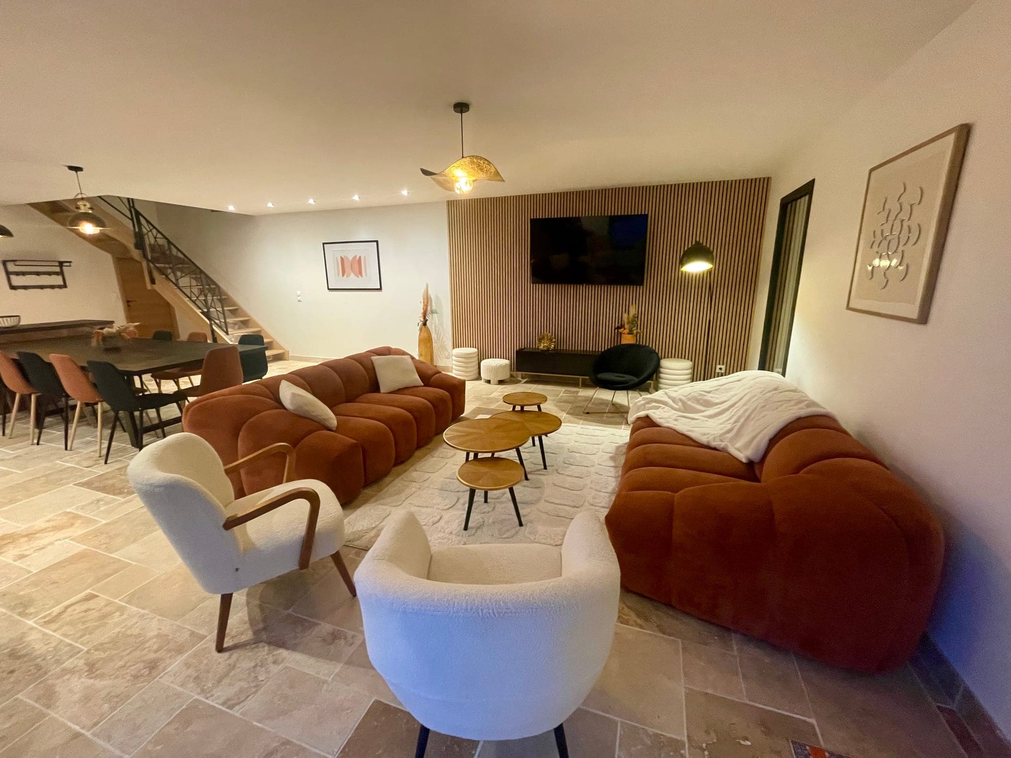 Large living room at Gîte Myrtille with terracotta velvet sofas and a wooden slatted wall